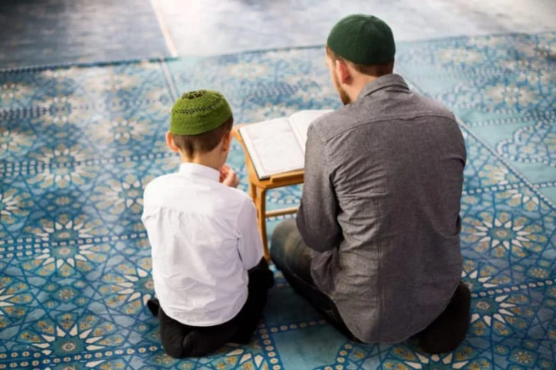 A parent and child reading the Quran together